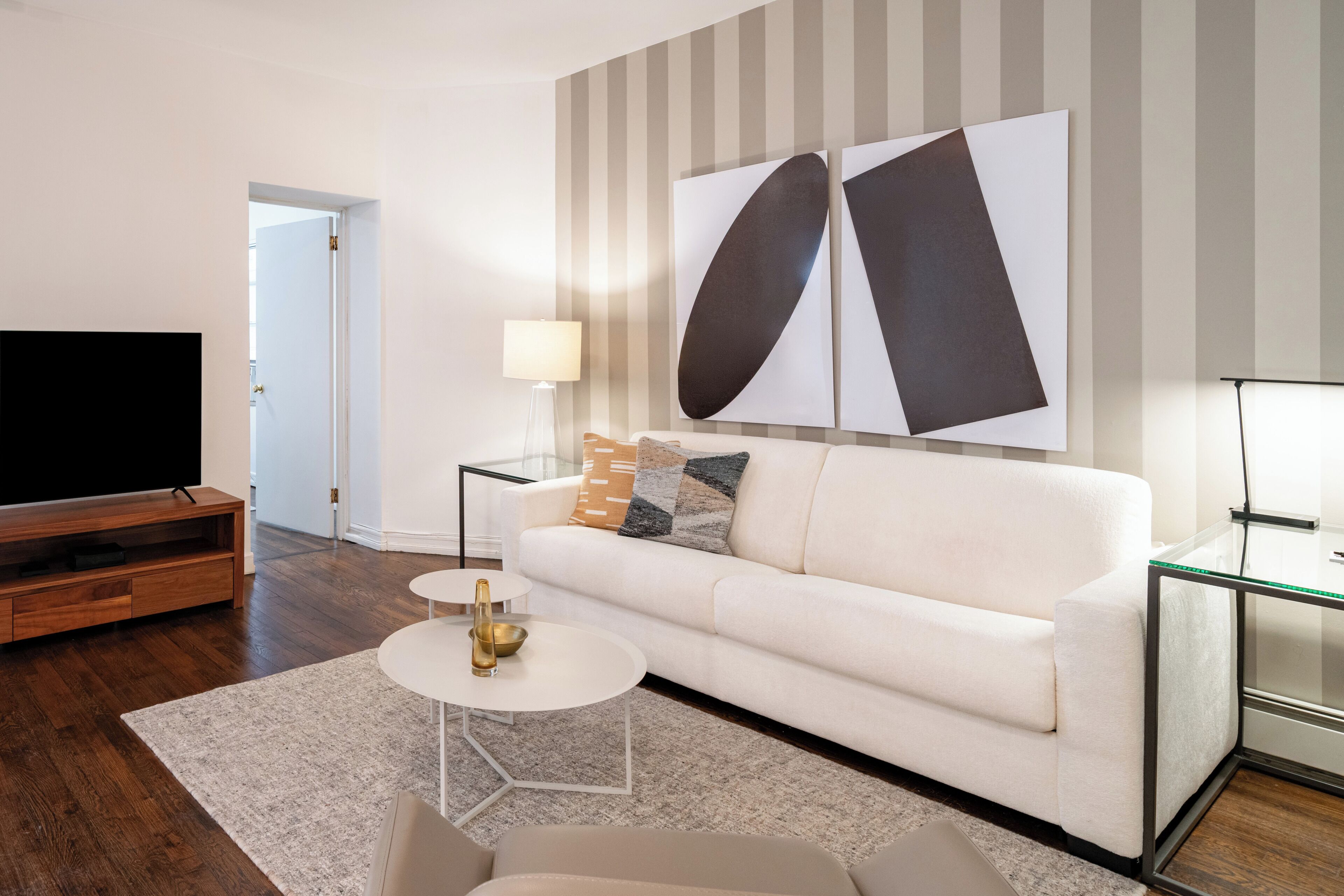 A modern living room with a sofa, coffee table, and a flat-screen TV.
