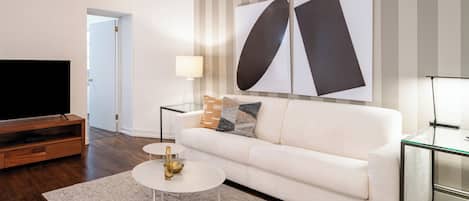 A modern living room with a sofa, coffee table, and a flat-screen TV.