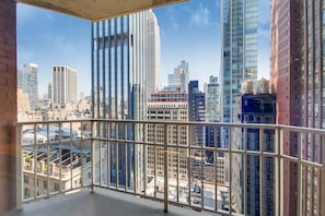 Un edificio alto con vista sulla città attraverso la ringhiera di un balcone.