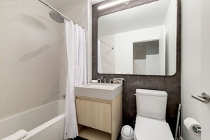 Un baño moderno con bañera, inodoro y lavamanos.