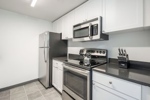 A modern kitchen with stainless steel appliances, including a refrigerator, microwave, stove, and oven. - Two Bedroom in Hoboken, Quick Access to NYC (Hoboken)