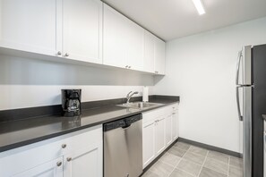 A modern kitchen with white cabinets, a black countertop, stainless steel appliances, and a dishwasher. - Two Bedroom in Hoboken, Quick Access to NYC (Hoboken)