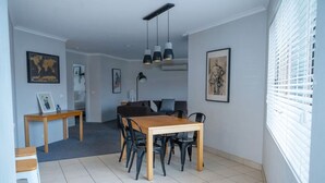 A dining area with a wooden table and chairs, a world map on the wall, and a framed picture.