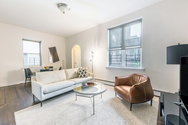 A modern living room with a sofa, coffee table, and leather chair.