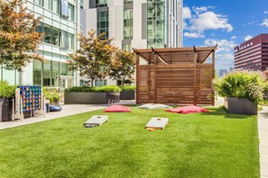 A well-maintained grassy area with outdoor seating and a wooden pergola structure.