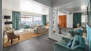 Un salon spacieux doté d’une grande fenêtre, d’un canapé, d’une table basse et d’un coin repas avec une table et des chaises.