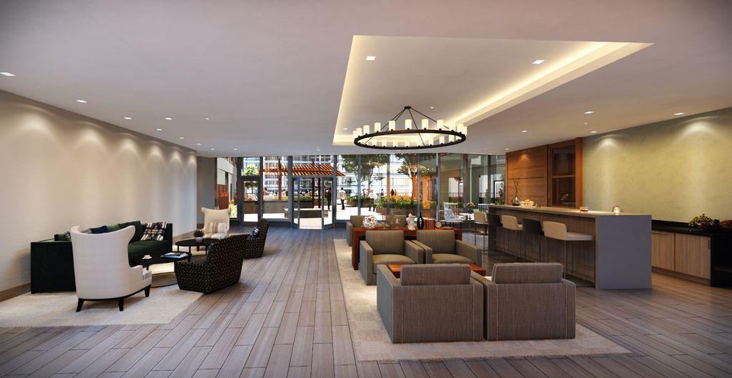 A spacious lobby with a reception desk, seating area, and a large chandelier.