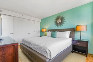 A neatly arranged hotel room with a large bed, two bedside tables with lamps, a mirror, and a wardrobe. - Boston One Bed With Luxury Building Amenities (Boston)