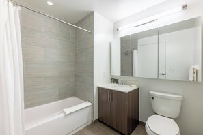 Een moderne badkamer met een badkuip, wastafel en toilet.