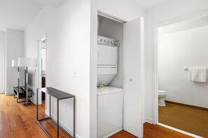 Ein modernes Badezimmer mit Toilette, einem weißen Waschbecken und einem Spiegel.