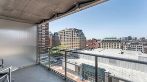 A balcony with a clear view of the cityscape, including high-rise buildings and a distinctive green-roofed structure. - Stylish One Bedroom Apartment in Back Bay (Boston)