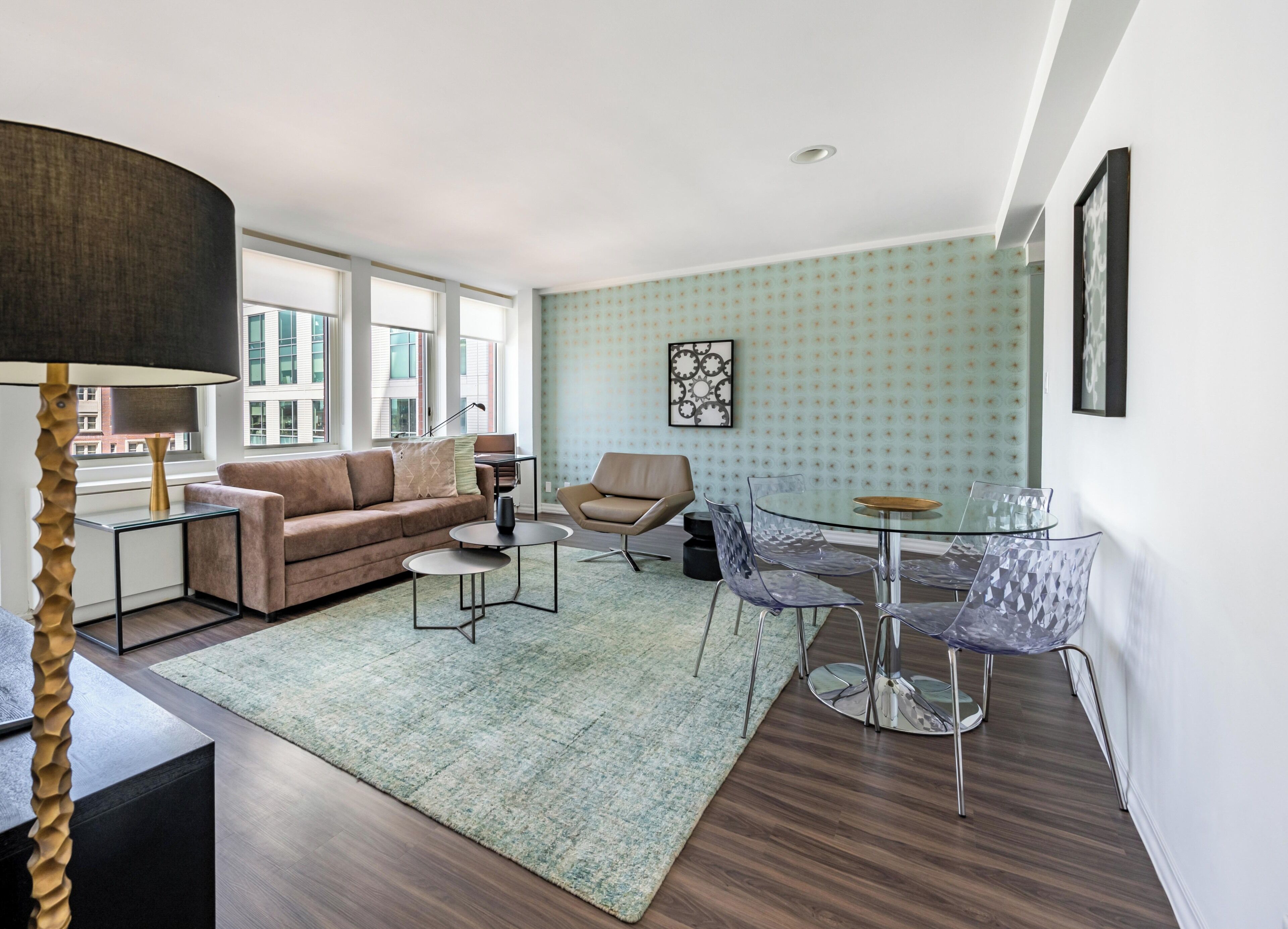 A modern living room with a sofa, coffee table, and glass dining table.