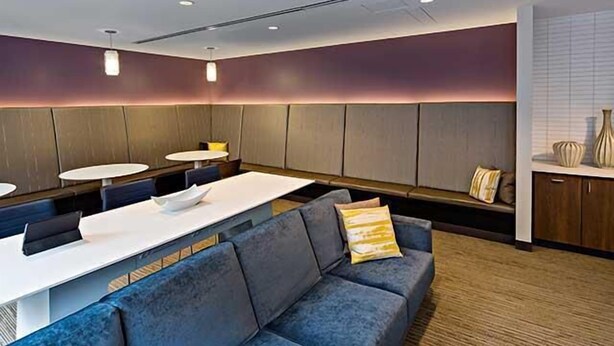 A modern hotel lobby with a seating area, a reception desk, and a counter. - Stylish One Bedroom Apartment in Back Bay (Boston)