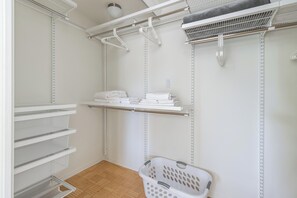 A laundry room with shelves, a drying rack, and a laundry basket.