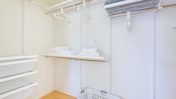 A laundry room with shelves for hanging clothes, a drying rack, and a laundry basket. - Modern 1 Bed Apartment in Central Back Bay, Boston (Boston)