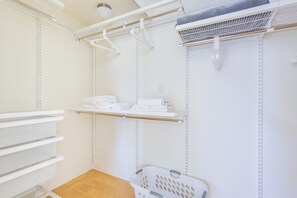A laundry room with shelves for hanging clothes, a drying rack, and a laundry basket. - Modern 1 Bed Apartment in Central Back Bay, Boston (Boston)