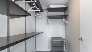 En rymlig klädkammare med öppna hyllor, plats för att hänga kläder och förvaringslådor.