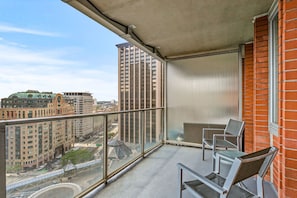 A balcony with a view of a cityscape, including high-rise buildings and a bridge. - Spacious and Modern One Bedroom, Back Bay (Boston)