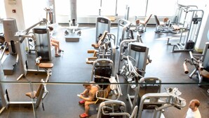 Une salle de sport équipée de divers appareils d’exercice et dotée d’une grande fenêtre à l’arrière-plan.