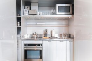 A modern kitchen with stainless steel appliances, a built-in oven, and a microwave.