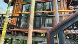 Un edificio de madera con balcón, rodeado de palmeras.