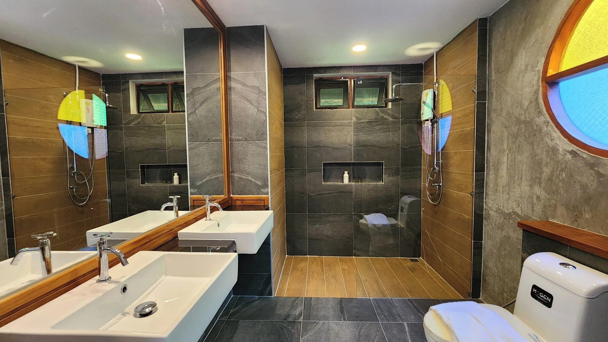 Un bagno moderno con due lavabi, una doccia e un water.