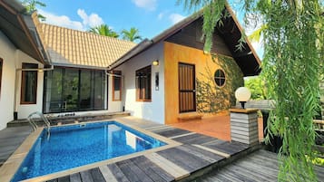 Enjoy a refreshing dip in the pool surrounded by a beautifully maintained garden and a spacious deck.
