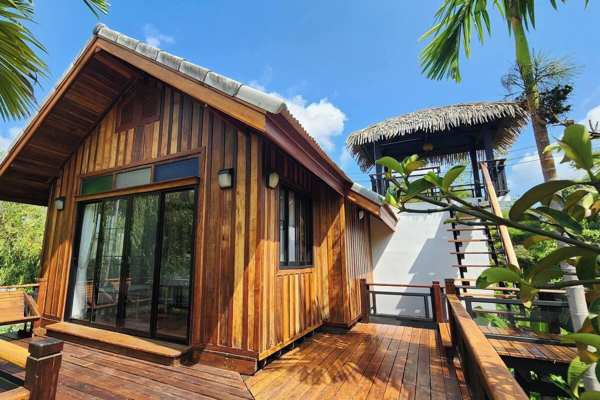 Una cabaña de madera con ventanas amplias y techo de paja.