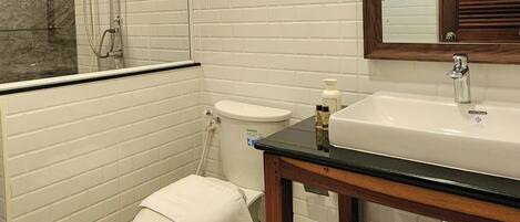 Een moderne badkamer met toilet, wastafel en douche.