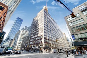 A multi-story building with a modern architectural design, featuring a mix of glass and concrete facades. - Spacious Studio With Luxury Amenities | Tribeca (New York)