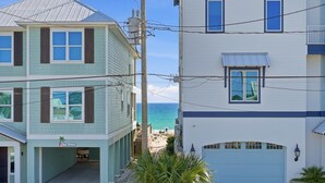 A coastal building with a garage and a visible beach.