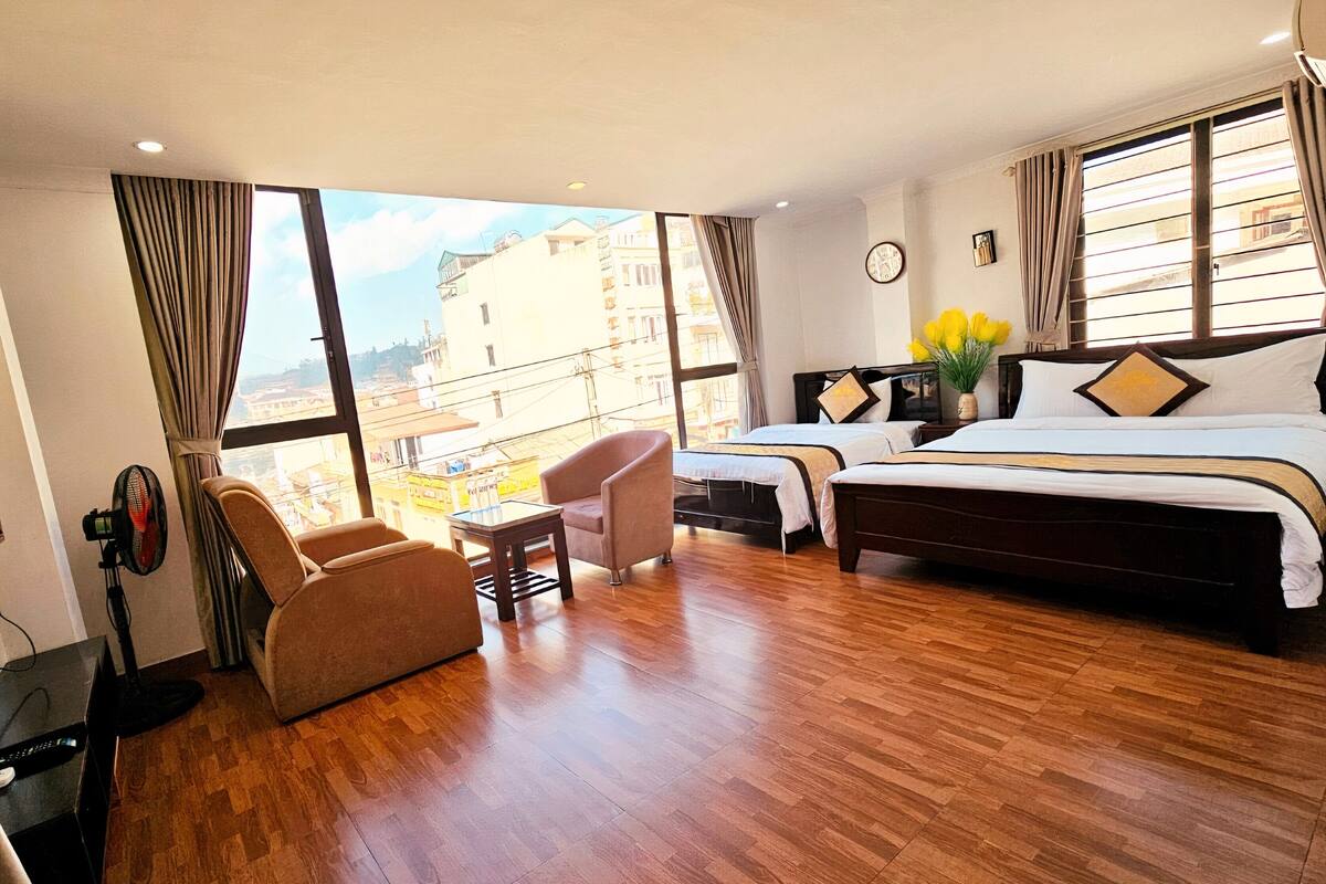 A hotel room with a large bed, a chair, a small table, and a TV.