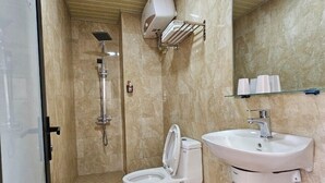 Een badkamer met toilet, wastafel en douche.