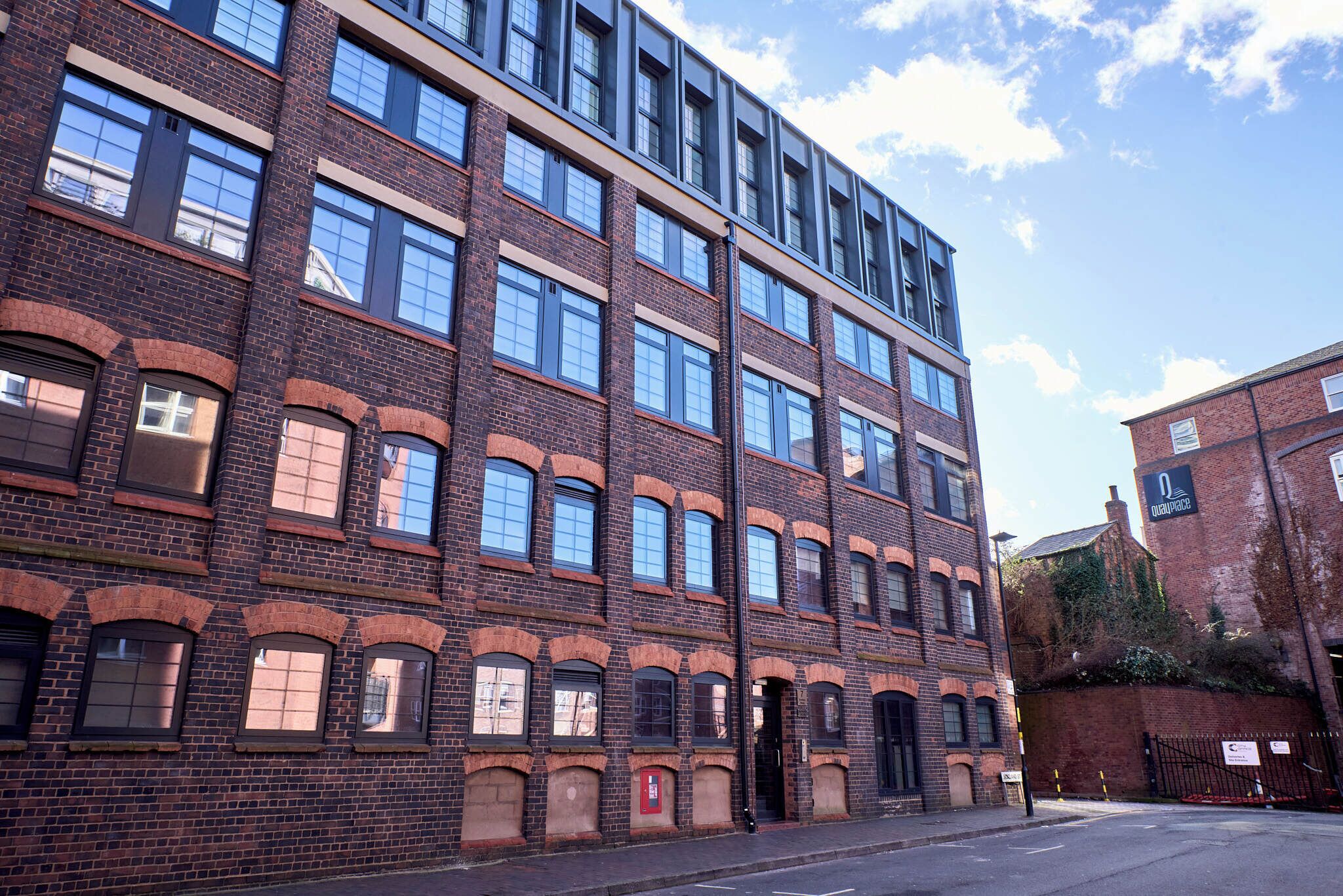 A multi-story brick building with large windows and a flat roof.