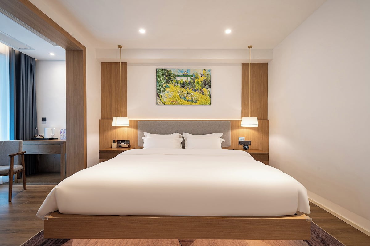 Una habitación de hotel con una cama grande, un escritorio y una silla.