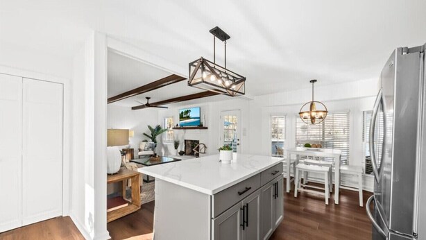 A modern kitchen with a large island, pendant lighting, and a built-in refrigerator. - The Grand Haven on the Ashley (North Charleston)