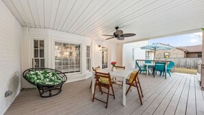 A covered patio with a table and chairs, a ceiling fan, and a view of the backyard. - The Grand Haven on the Ashley (North Charleston)