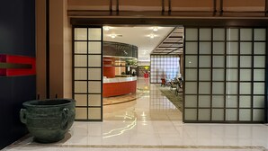 A spacious lobby with a polished marble floor, a large decorative vase, and a reception area with a modern design. - Rongzhen International Hotel - Zhonglou Drum Tower Branch (Xi'an)