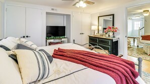 A bedroom with a bed, a ceiling fan, a TV, a dresser, and a mirror. - Fire Pits, Creek View: Historic Virginia Farmhouse (Bealeton)