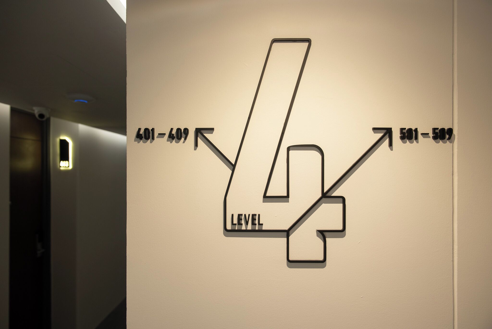 Un mur orné de flèches indiquant les directions et d’indicateurs de niveau, ce qui laisse supposer qu’il s’agit d’un bâtiment à plusieurs étages.