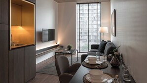Un espacio habitable moderno y compacto con comedor, kitchenette y zona de estar.