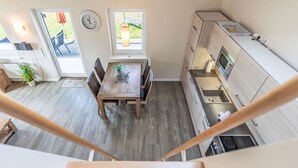 Una cocina moderna con comedor, suelo de madera y vistas al exterior.