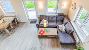 Een moderne woonkamer met een bank, salontafel en een eethoek.