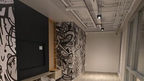 A modern room with a large TV, bean bags, and a wall with abstract art. - Departamento de lujo Quito Le Parc -1002 (Quito)