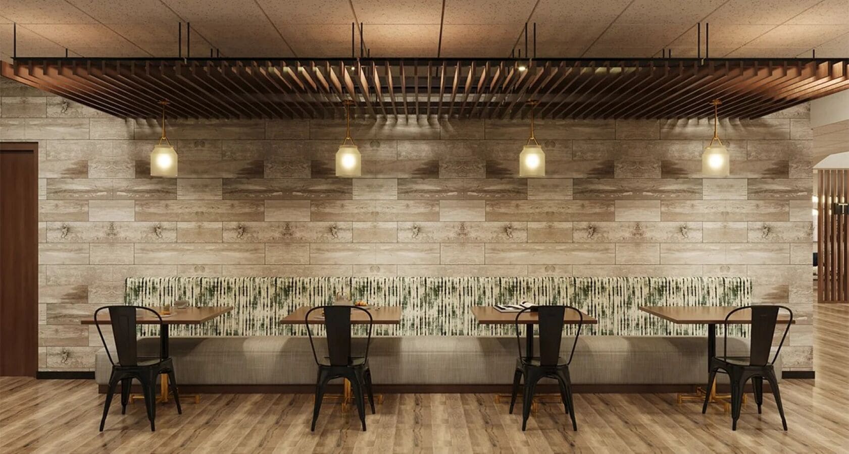 A modern restaurant with wooden flooring, a stone wall, and a bench seating area.