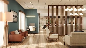 A modern hotel lobby with a seating area, a desk, and a decorative light fixture. - The Bridges Hotel  (Natchez)