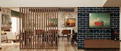 A modern living room with a wooden partition, a fireplace, a dining area, and a TV mounted on a brick wall.