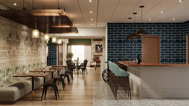 A modern restaurant with a long counter, multiple seating areas, and a distinctive blue brick wall. - The Bridges Hotel  (Natchez)