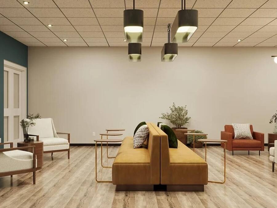A modern lobby with a sofa, chairs, and a coffee table.