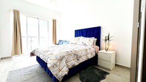 Un dormitorio moderno con una cama grande, una mesita de noche y vistas al exterior.